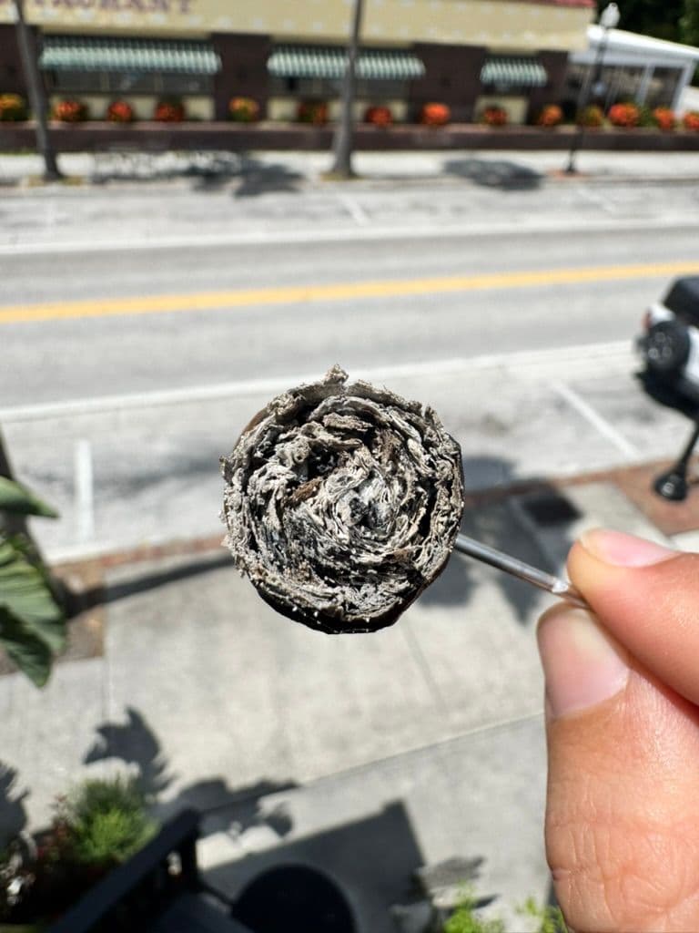 Final nub of Meerapfel Richard on a cigar pick over a city street